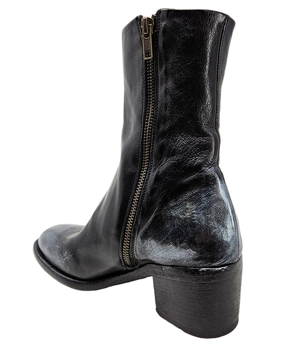 Mid-heel ankle boot crafted from premium leather with a softly rounded toe, artisanal distressed detailing at the toe and heel, and a stacked block heel. Features a full side zipper for easy entry, a leather-lined interior for comfort, and a durable leath