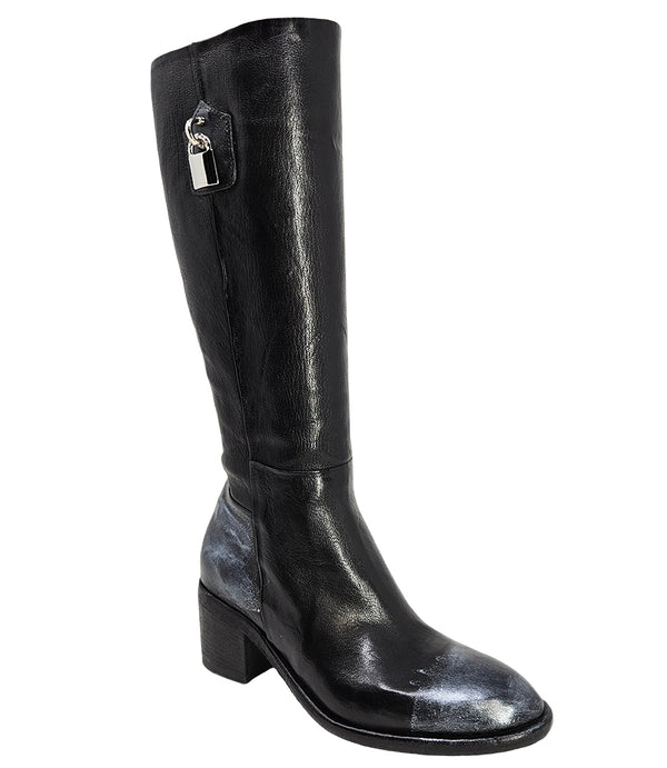 Tall leather boot featuring a softly rounded toe, mid-height stacked block heel, full side zipper for easy on and off, and a decorative metal lock accent near the top shaft. Crafted from premium leather with artisanal distressed detailing at the toe and h
