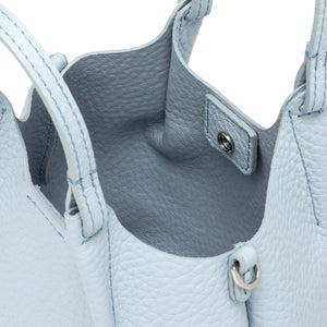 Close-up of a light blue leather handbag with visible stitching and hardware.