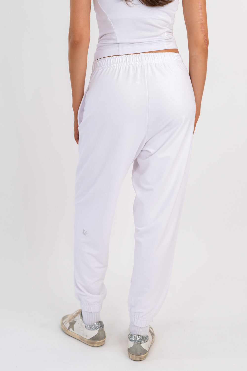 White sweatpants with elastic waistband and tapered cuffs