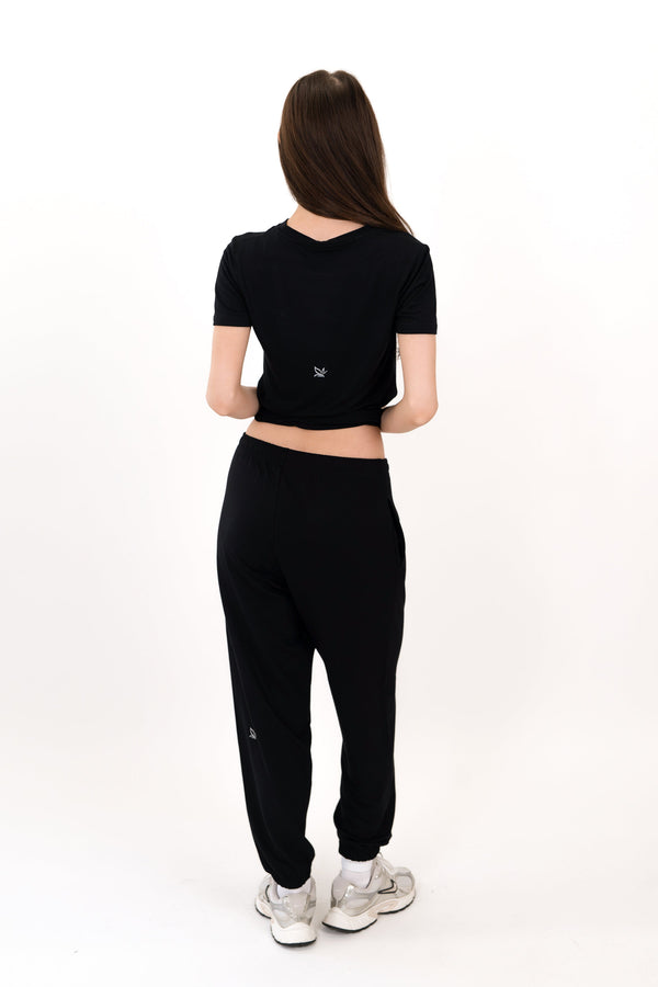 Model wearing The Solace Sweatpant in Onyx by ON/OFF Essentials, made from 95% bamboo fleece.