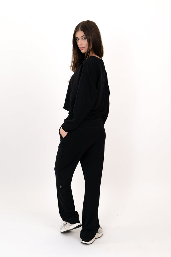 Model wearing The Solace Wide Leg Sweatpant in Onyx by ON/OFF Essentials, made from 95% bamboo fleece.