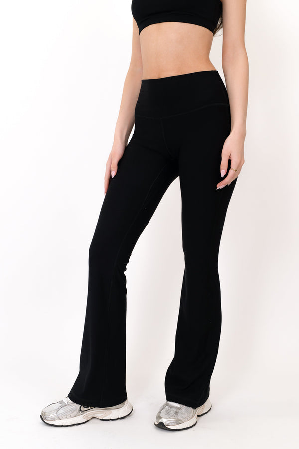Model wearing The Core Flare Legging in Onyx by ON/OFF Essentials, made from 95% bamboo.