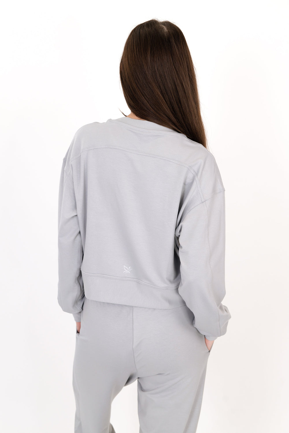 Gray crew neck pullover with long sleeves and knotted drawstring waist hem.