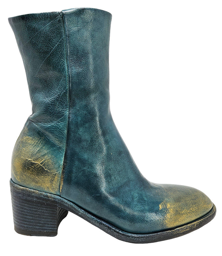 Mid-heel ankle boot crafted from premium leather with a softly rounded toe, artisanal distressed detailing at the toe and heel, and a stacked block heel. Features a full side zipper for easy entry, a leather-lined interior for comfort, and a durable leath