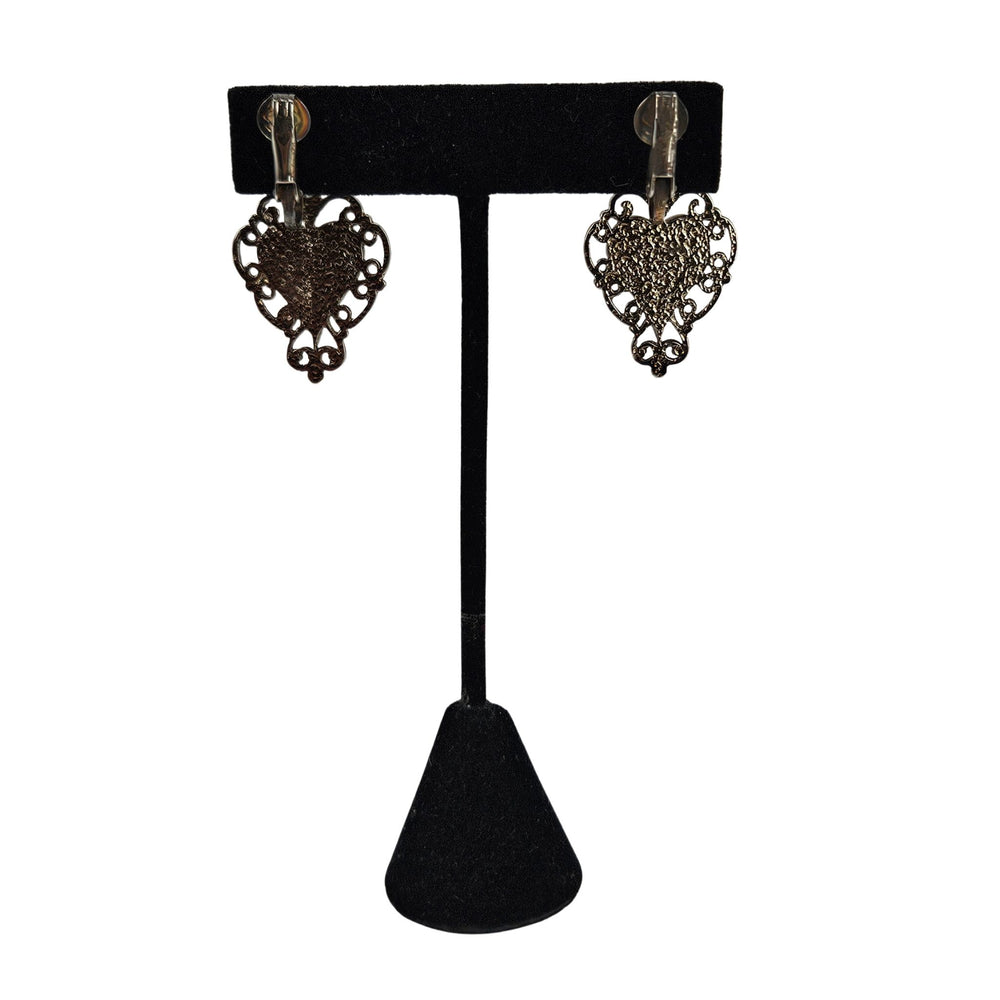 Gold-tone heart dangle earrings with pink enamel heart and ornate filigree frames.