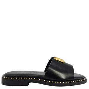 Black sandal with gold accents on a white background