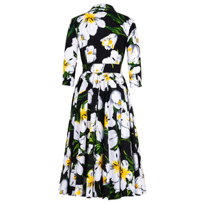 Floral dress with white flowers and green leaves on a black background