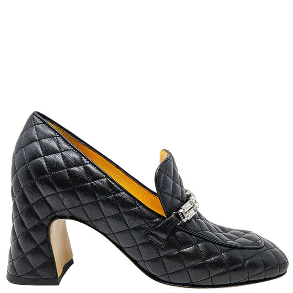 Black quilted high-heeled shoe with a decorative buckle on a white background