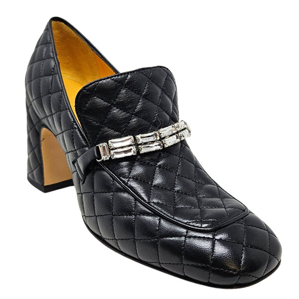 Black quilted loafer with a decorative strap on a white background