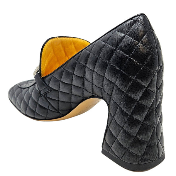 Black quilted high-heeled shoe with yellow lining on a white background