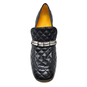 Black quilted loafer with a decorative band on a white background