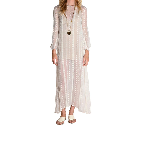 Woman wearing a long, sheer polka dot dress on a white background