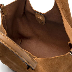 Close-up of a brown leather bag with visible stitching on a white background