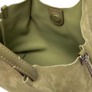 Close-up of a green handbag with visible stitching and a keychain.