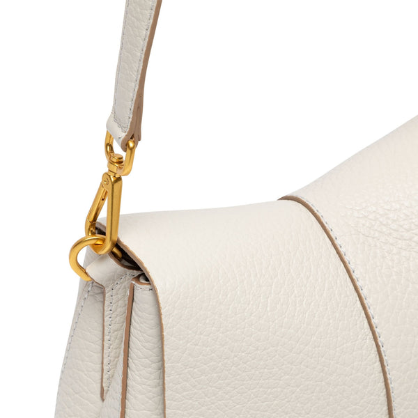 Close-up of a white handbag with a gold clasp on a white background