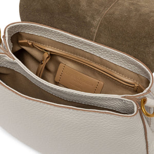 Close-up of a beige handbag with a gold zipper and visible brand label.