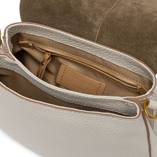 Close-up of a beige handbag with a gold zipper and visible brand label.