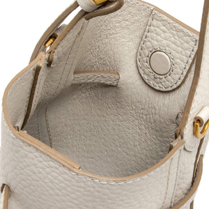 Close-up of a light gray leather handbag with gold accents