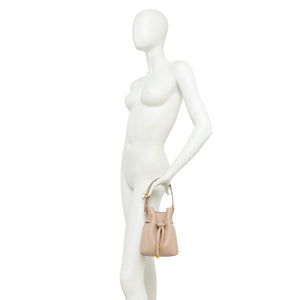 Mannequin holding a beige handbag against a white background