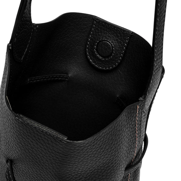 Close-up of a black leather bag with visible stitching on a white background
