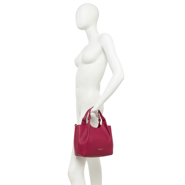 Mannequin holding a pink handbag on a white background