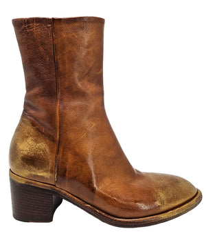 Mid-heel ankle boot crafted from premium leather with a softly rounded toe, artisanal distressed detailing at the toe and heel, and a stacked block heel. Features a full side zipper for easy entry, a leather-lined interior for comfort, and a durable leath