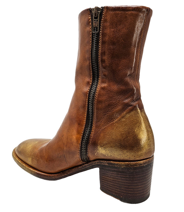 Mid-heel ankle boot crafted from premium leather with a softly rounded toe, artisanal distressed detailing at the toe and heel, and a stacked block heel. Features a full side zipper for easy entry, a leather-lined interior for comfort, and a durable leath