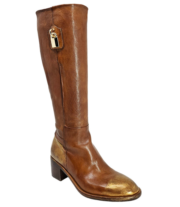 Tall leather boot featuring a softly rounded toe, mid-height stacked block heel, full side zipper for easy on and off, and a decorative metal lock accent near the top shaft. Crafted from premium leather with artisanal distressed detailing at the toe and h