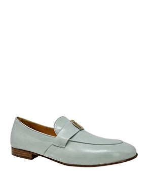 A leather loafer with a flat sole and rounded toe, featuring a small metal lock accent centered on the upper strap. Designed by Madison in Beverly Hills and handcrafted in Italy.