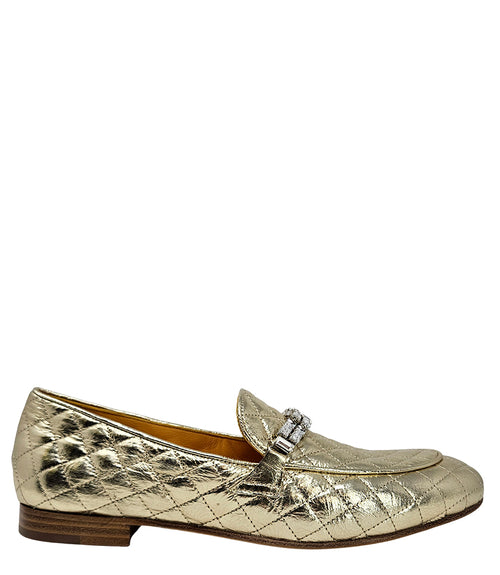 A quilted leather flat loafer with a low stacked heel and rounded toe, featuring a decorative strap adorned with rectangular gemstone-style embellishments. Designed by Madison in Beverly Hills and handcrafted in Italy.