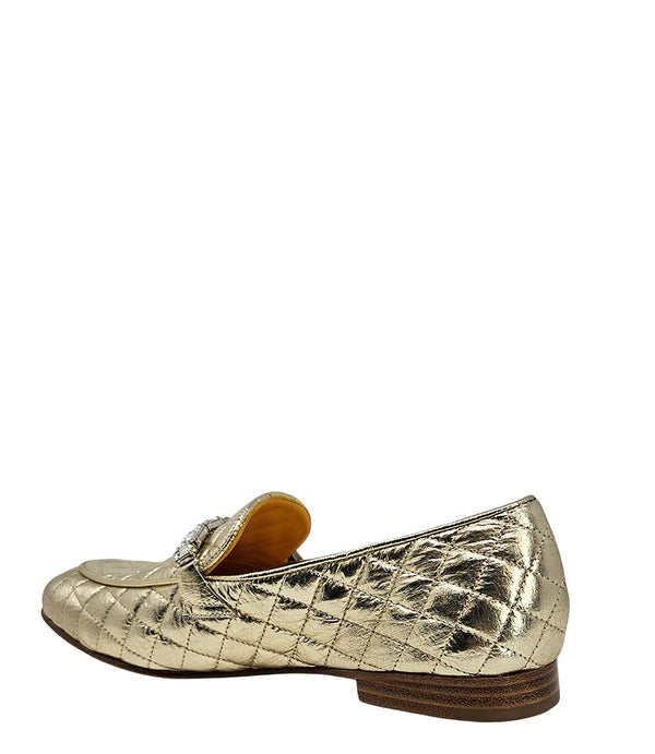A quilted leather flat loafer with a low stacked heel and rounded toe, featuring a decorative strap adorned with rectangular gemstone-style embellishments. Designed by Madison in Beverly Hills and handcrafted in Italy.