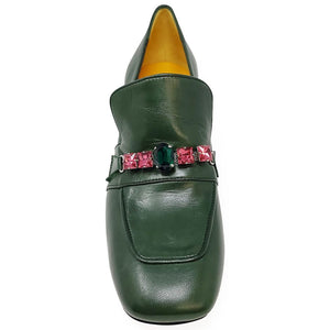 Green loafer shoe with pink gem embellishments on a white background