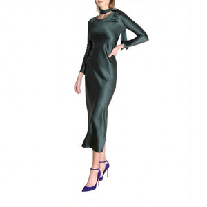 Woman wearing a dark green dress with long sleeves on a white background