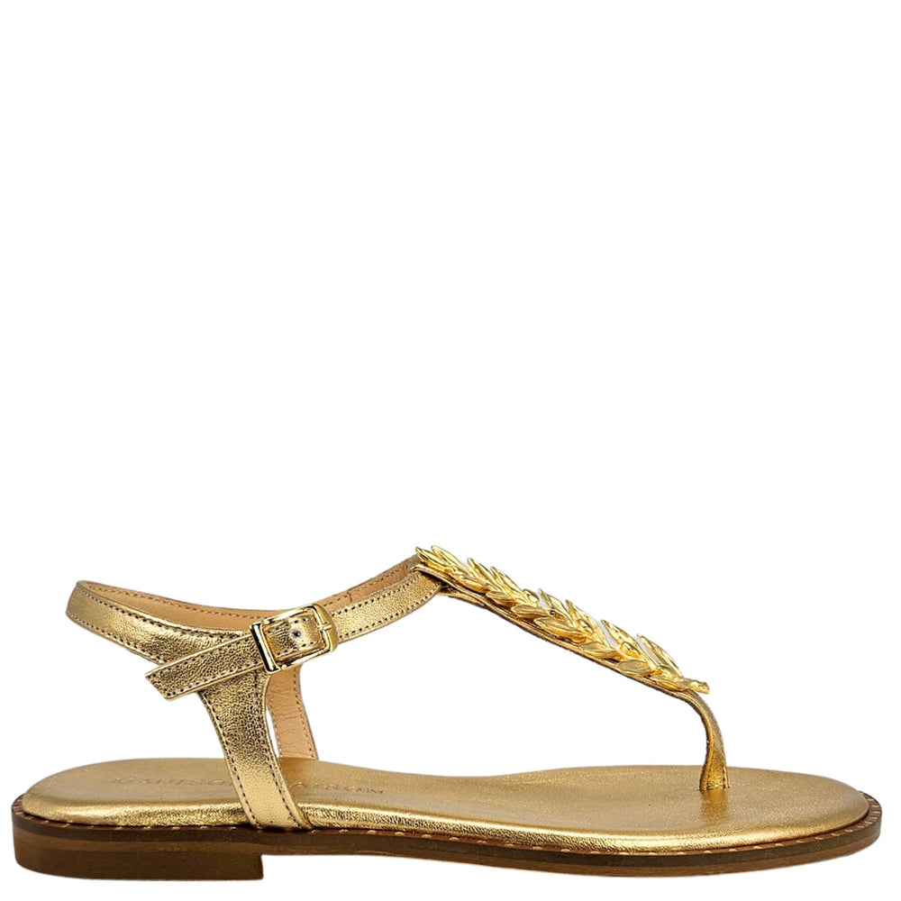 Gold sandal with decorative strap on a white background