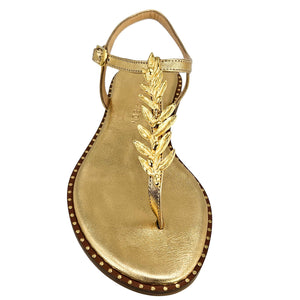 Gold sandal with leaf design on a white background
