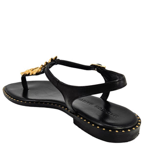 Black sandal with gold accents on a white background