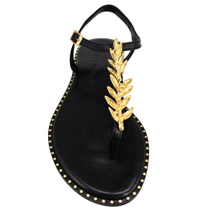 Black sandal with gold leaf design on a white background