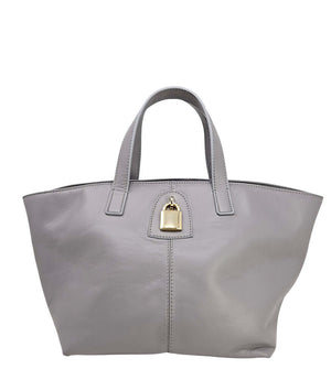 "A light grey leather tote bag with short handles and a structured silhouette, featuring a central vertical seam and a small gold padlock accent beneath the handle. Designed by Madison in Beverly Hills and handmade in Italy.