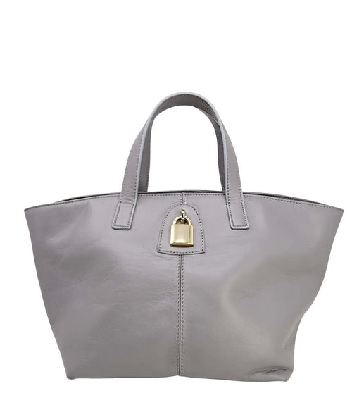 "A light grey leather tote bag with short handles and a structured silhouette, featuring a central vertical seam and a small gold padlock accent beneath the handle. Designed by Madison in Beverly Hills and handmade in Italy.