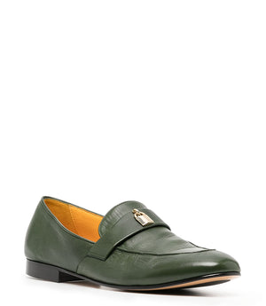 A leather loafer with a flat sole and rounded toe, featuring a small metal lock accent centered on the upper strap. Designed by Madison in Beverly Hills and handcrafted in Italy.