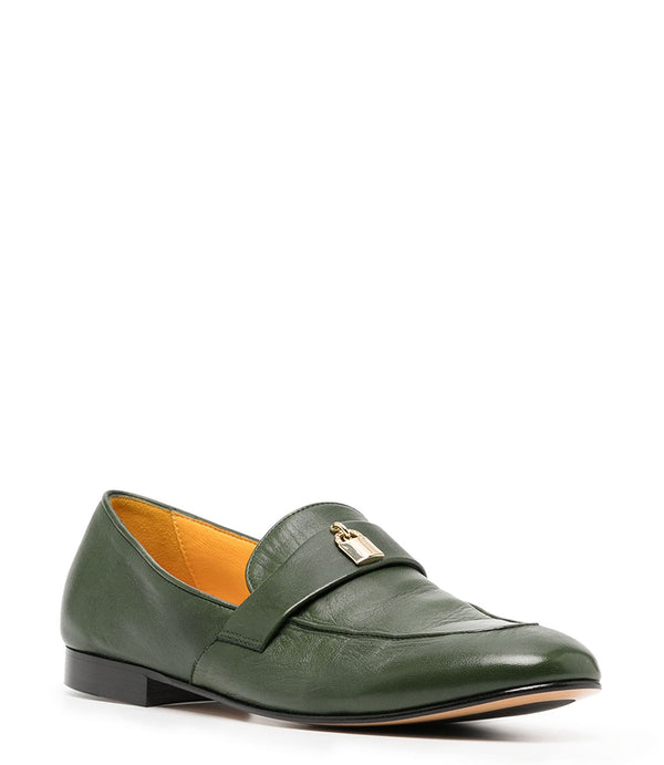 A leather loafer with a flat sole and rounded toe, featuring a small metal lock accent centered on the upper strap. Designed by Madison in Beverly Hills and handcrafted in Italy.
