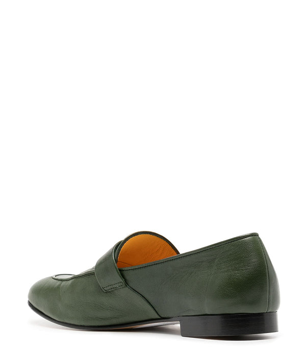 A leather loafer with a flat sole and rounded toe, featuring a small metal lock accent centered on the upper strap. Designed by Madison in Beverly Hills and handcrafted in Italy.