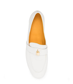 A leather loafer with a flat sole and rounded toe, featuring a small metal lock accent centered on the upper strap. Designed by Madison in Beverly Hills and handcrafted in Italy.