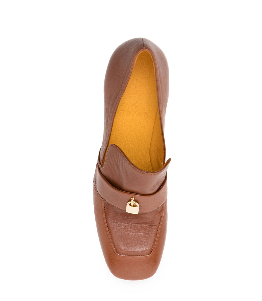 
                      
                        A leather loafer with a block heel, square toe, and a small metal lock detail centered on the upper strap. Designed by Madison in Beverly Hills and handcrafted in Italy.
                      
                    