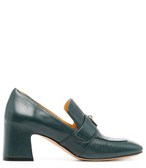 A leather loafer with a block heel, square toe, and a small metal lock detail centered on the upper strap. Designed by Madison in Beverly Hills and handcrafted in Italy.