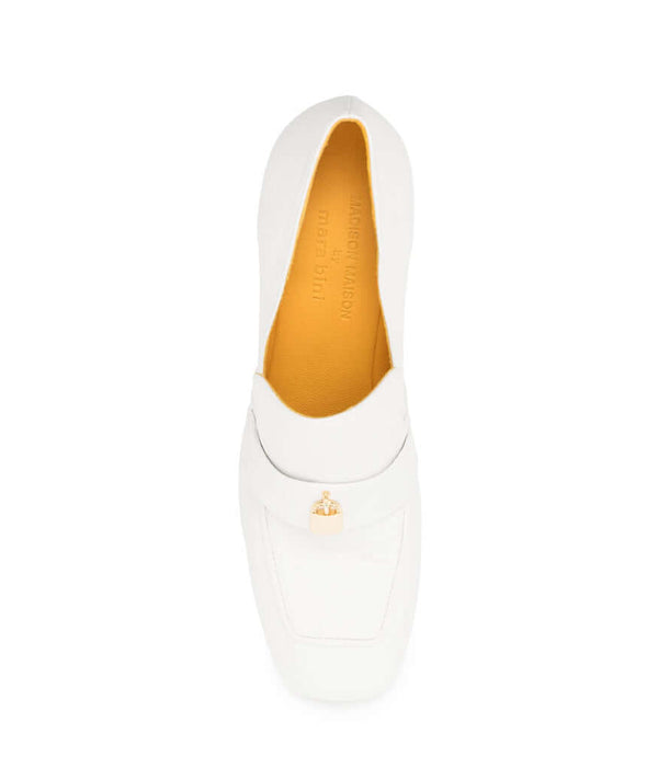A leather loafer with a block heel, square toe, and a small metal lock detail centered on the upper strap. Designed by Madison in Beverly Hills and handcrafted in Italy.