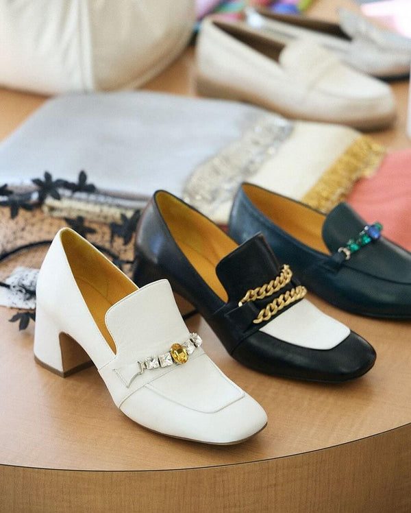 A leather heeled loafer with a block heel and square toe, featuring a decorative band with faceted gemstone-style embellishments across the upper. Designed by Madison in Beverly Hills and handcrafted in Italy.