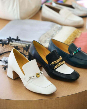 A leather heeled loafer with a block heel and square toe, featuring a decorative band with faceted gemstone-style embellishments across the upper. Designed by Madison in Beverly Hills and handcrafted in Italy.