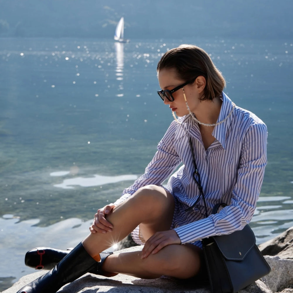 
                      
                        A mid-calf leather boot with a block heel and square toe, featuring a decorative metal accent across the toe. Designed by Madison in Beverly Hills and handcrafted in Italy.
                      
                    